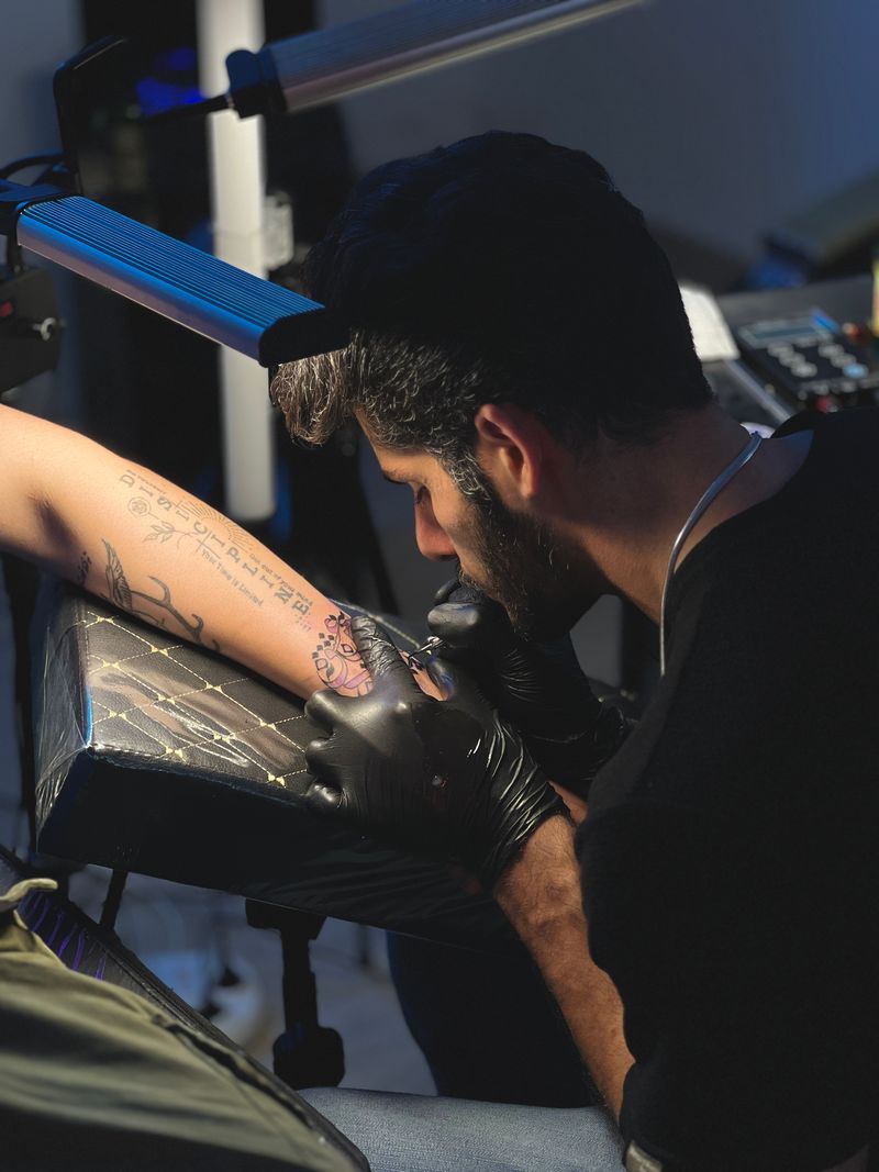 Artista tatuando com foco no traço