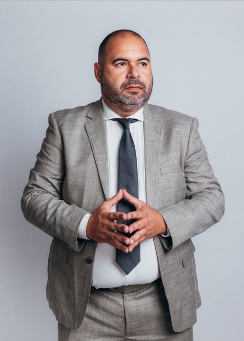 Free Professional businessman in a gray suit standing confidently against a plain background. Stock Photo