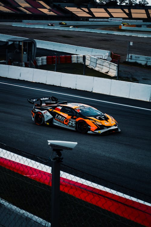 High-Speed Racing Car on Track at Dusk · Free Stock Photo