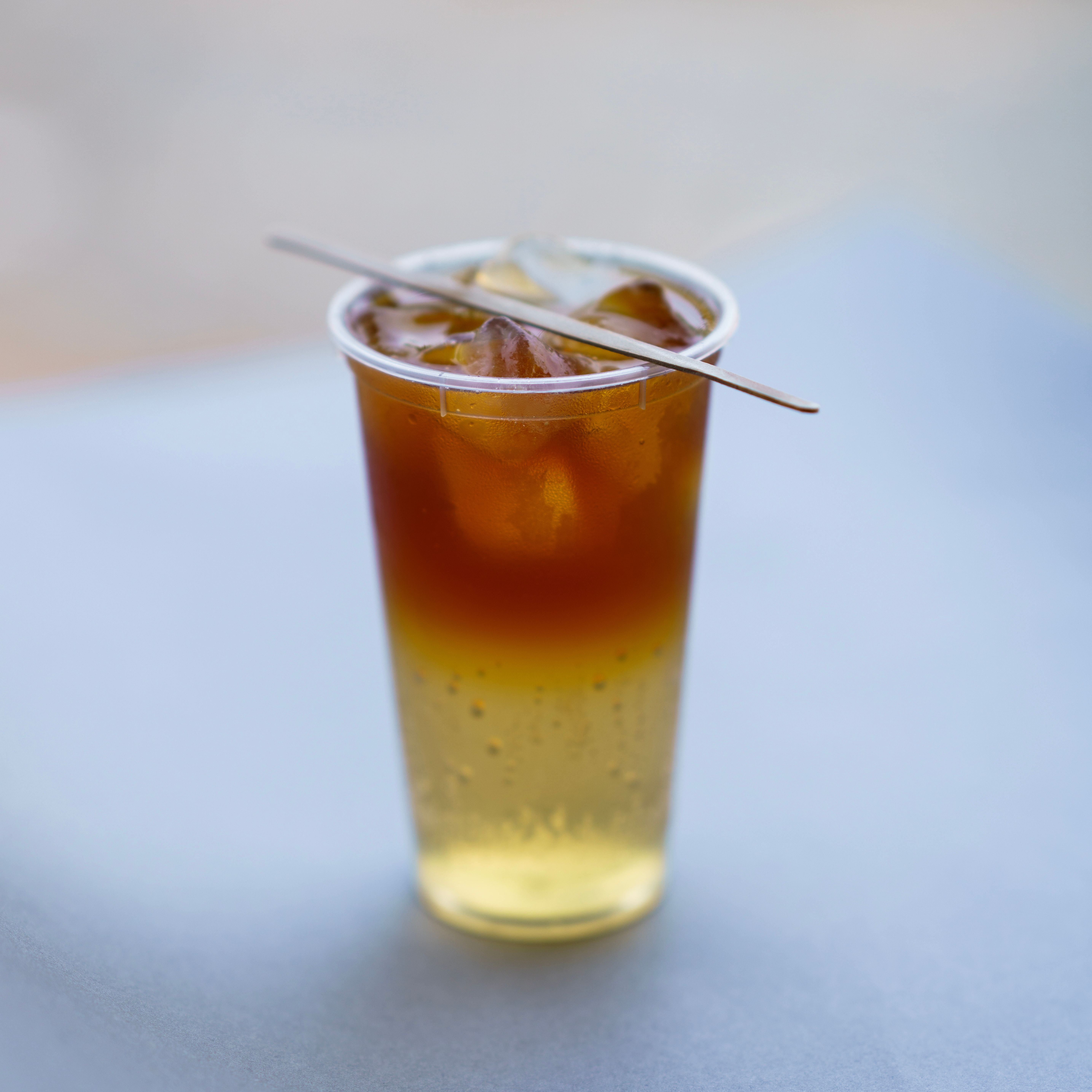 Chilled cold brew coffee in a plastic cup with a straw, perfect for a hot summer day.