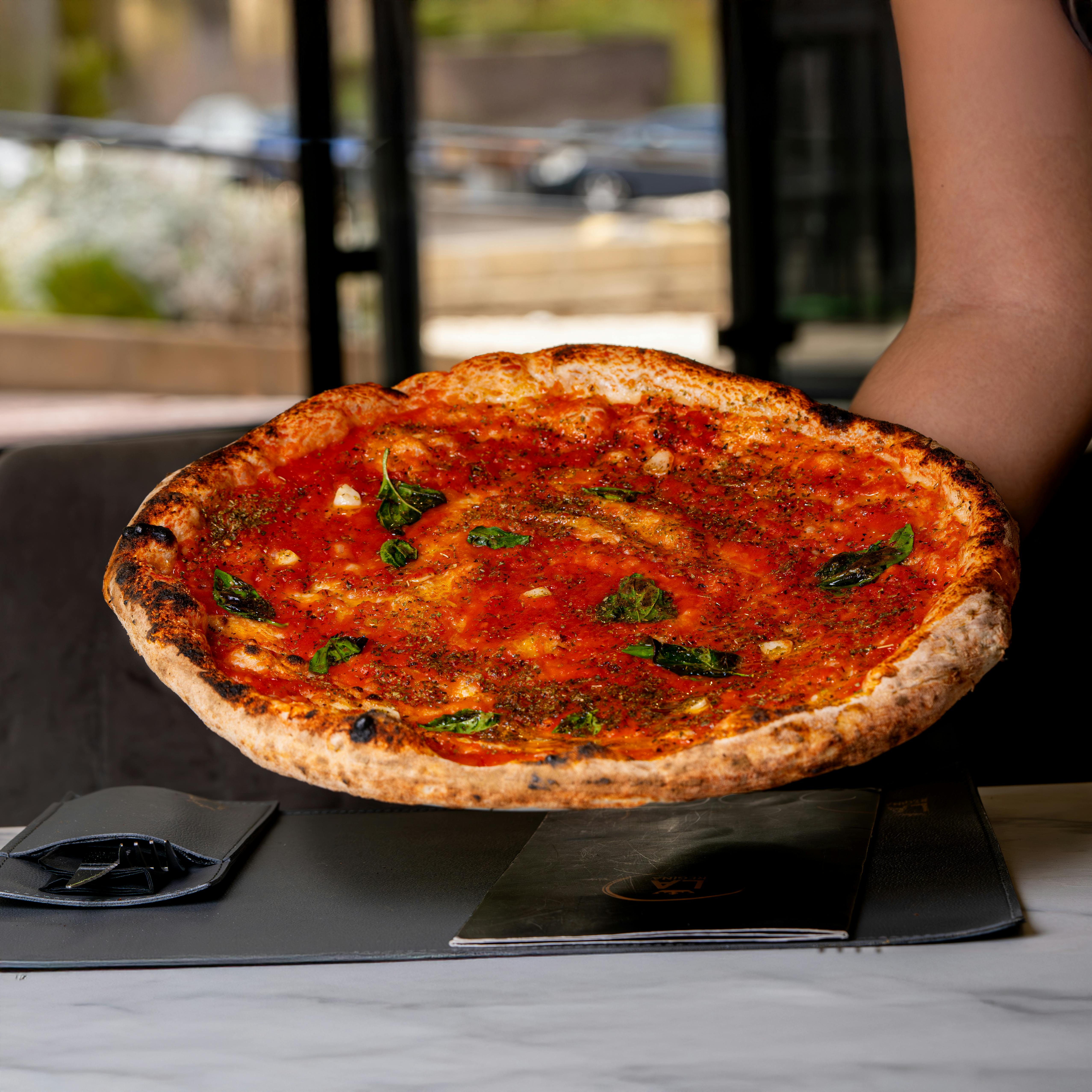 Delicious Margherita pizza with fresh basil served at a restaurant.