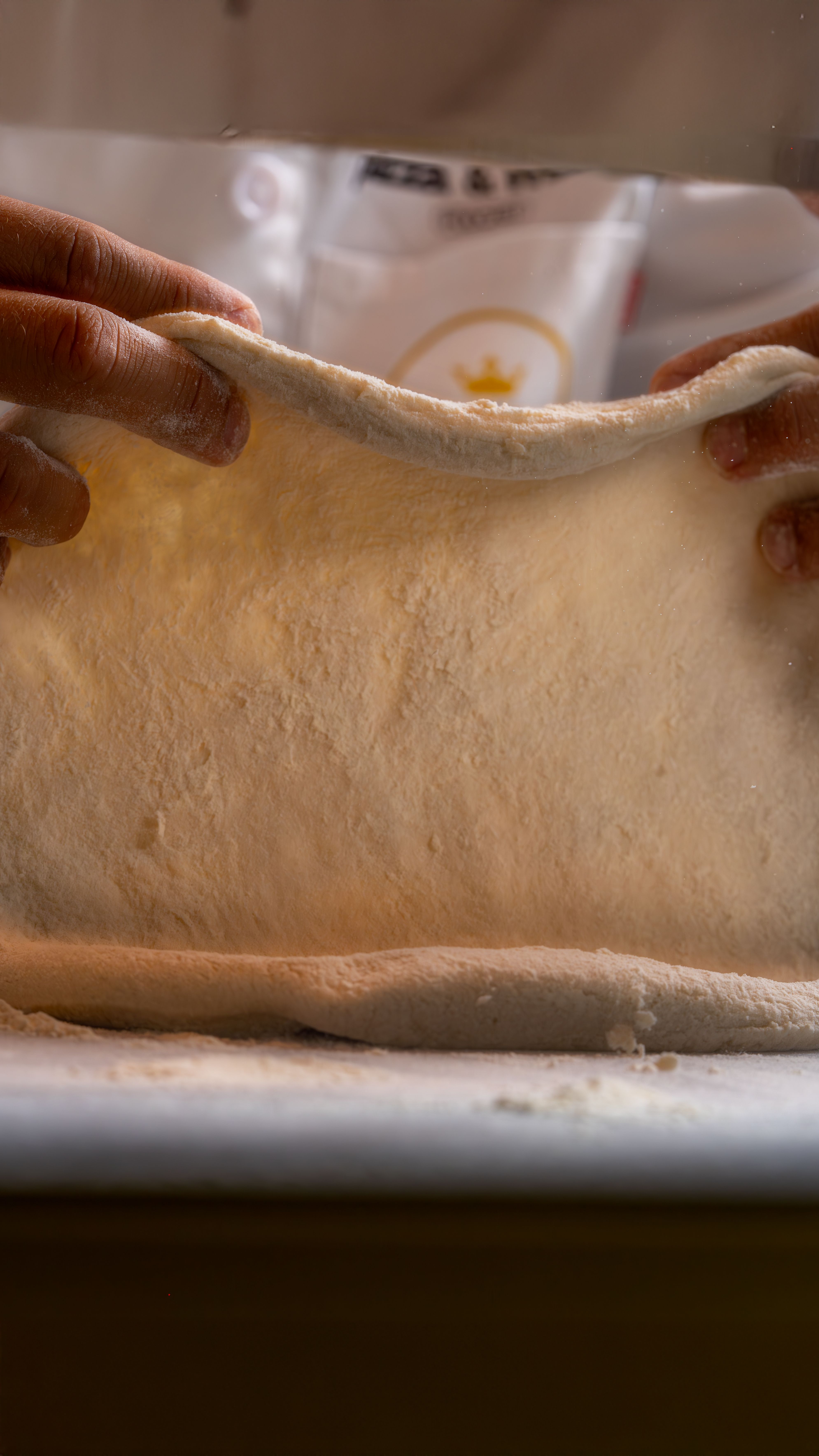 Hands stretching fresh pizza dough at Presto! Pizza