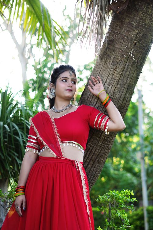 Free A woman in traditional Indian attire posing by a palm tree, capturing the essence of cultural elegance. Stock Photo