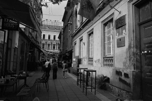 Monochrome street scene with cafes and walking people, urban vibe.