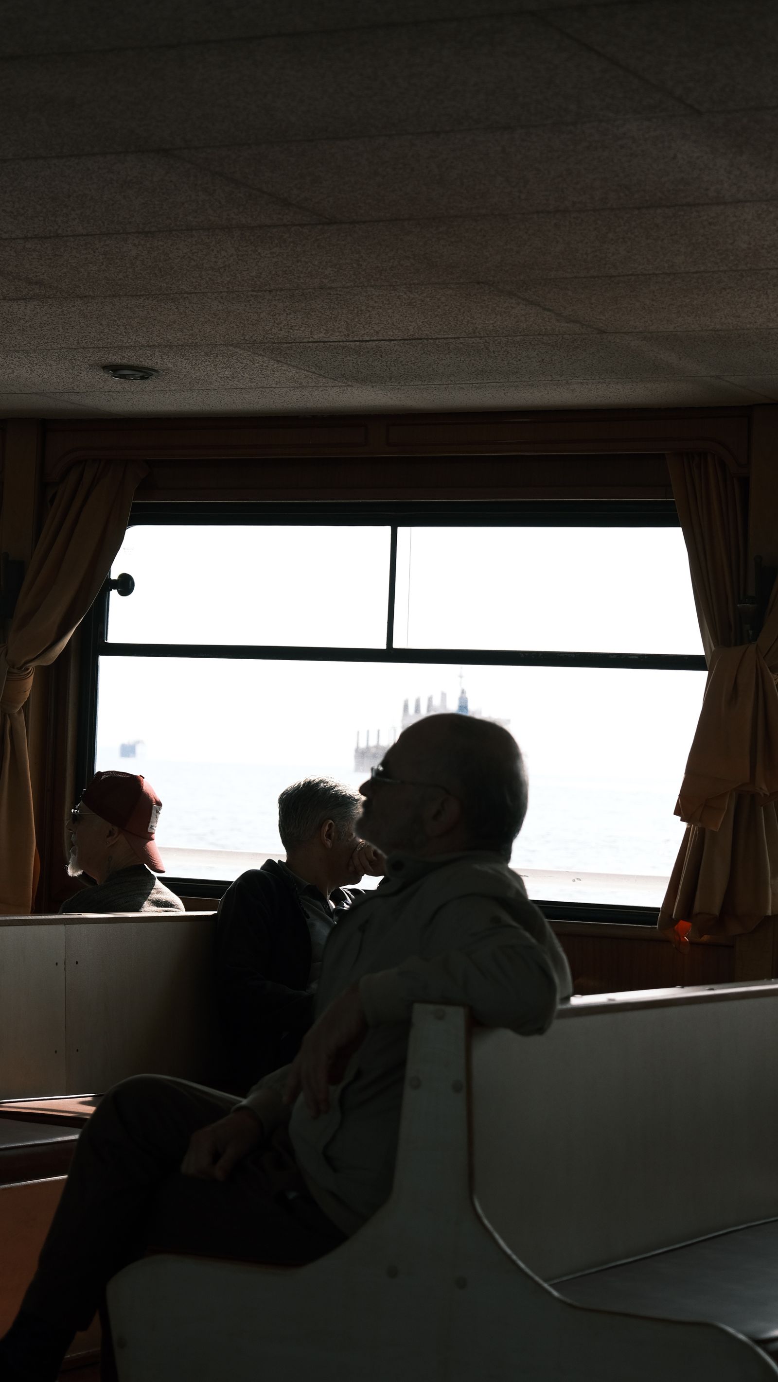 Passengers using travel information while looking through ferry windows