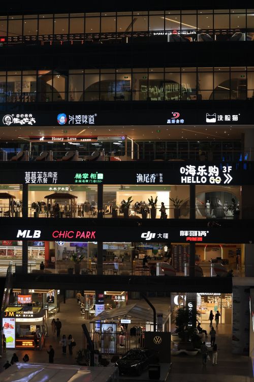 Free Urban shopping center illuminated with bright signs and bustling activity. Stock Photo