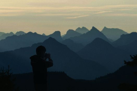 A photographer captures stunning mountain silhouettes at twilight.
