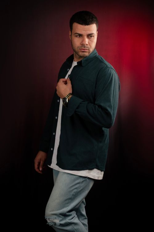 Free Stylish male posing against dark backdrop with vibrant red light accent Stock Photo