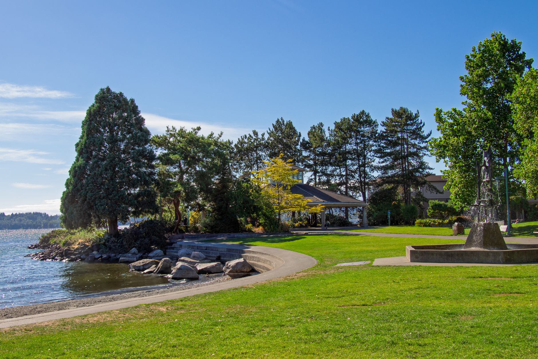 Scenic view of a peaceful park by the lake in Kirkland with lush green trees.
