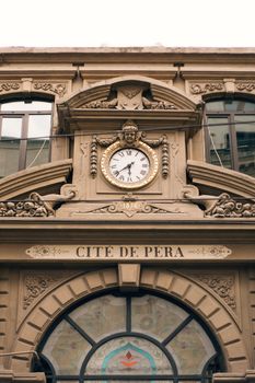 Elegant facade of the Cité de Péra with an ornate clock and architectural details.