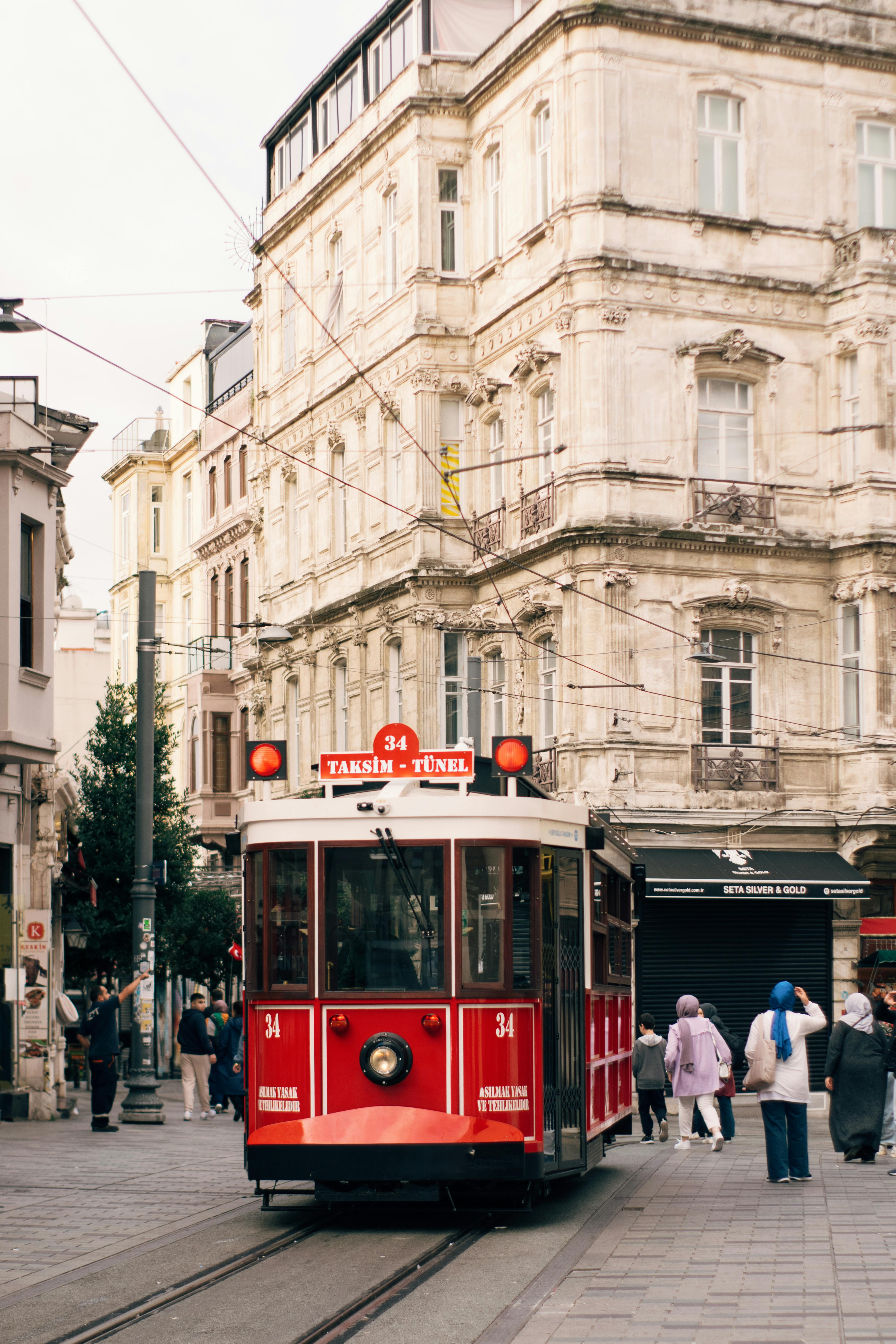 Iconic red tram on bustling street in Istanbul, capturing urban vintage charm.