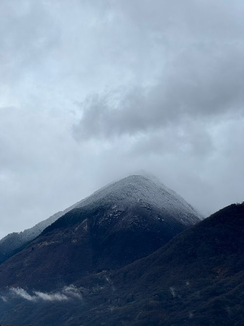 Free Scenic view of a snow-dusted mountain peak in Piantedo, Italy, with overcast skies. Stock Photo