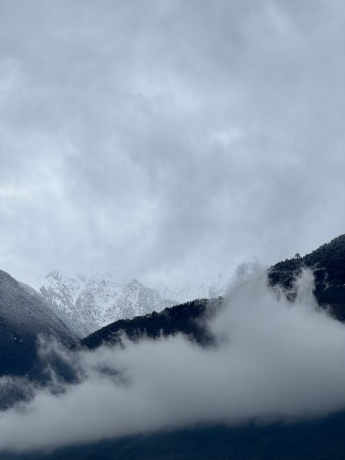 Free Snow-capped mountain peaks surrounded by mist in Piantedo, Lombardy, Italy. Stock Photo