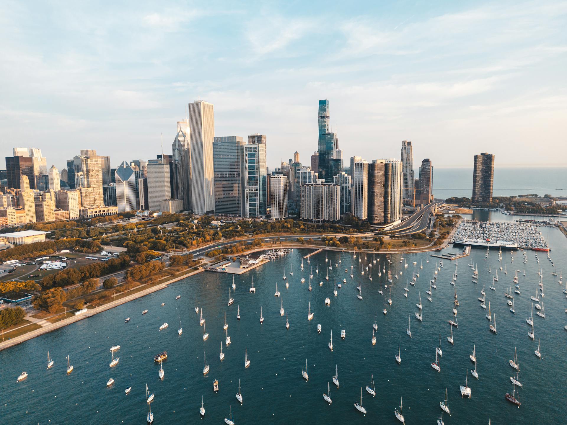 An aerial view of Chicago's skyline with a bustling marina filled with boats on a clear day.