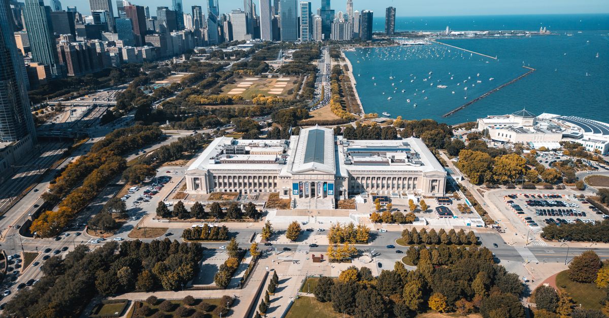 Aerial view of Chicago skyline with lakefront and museum in foreground.