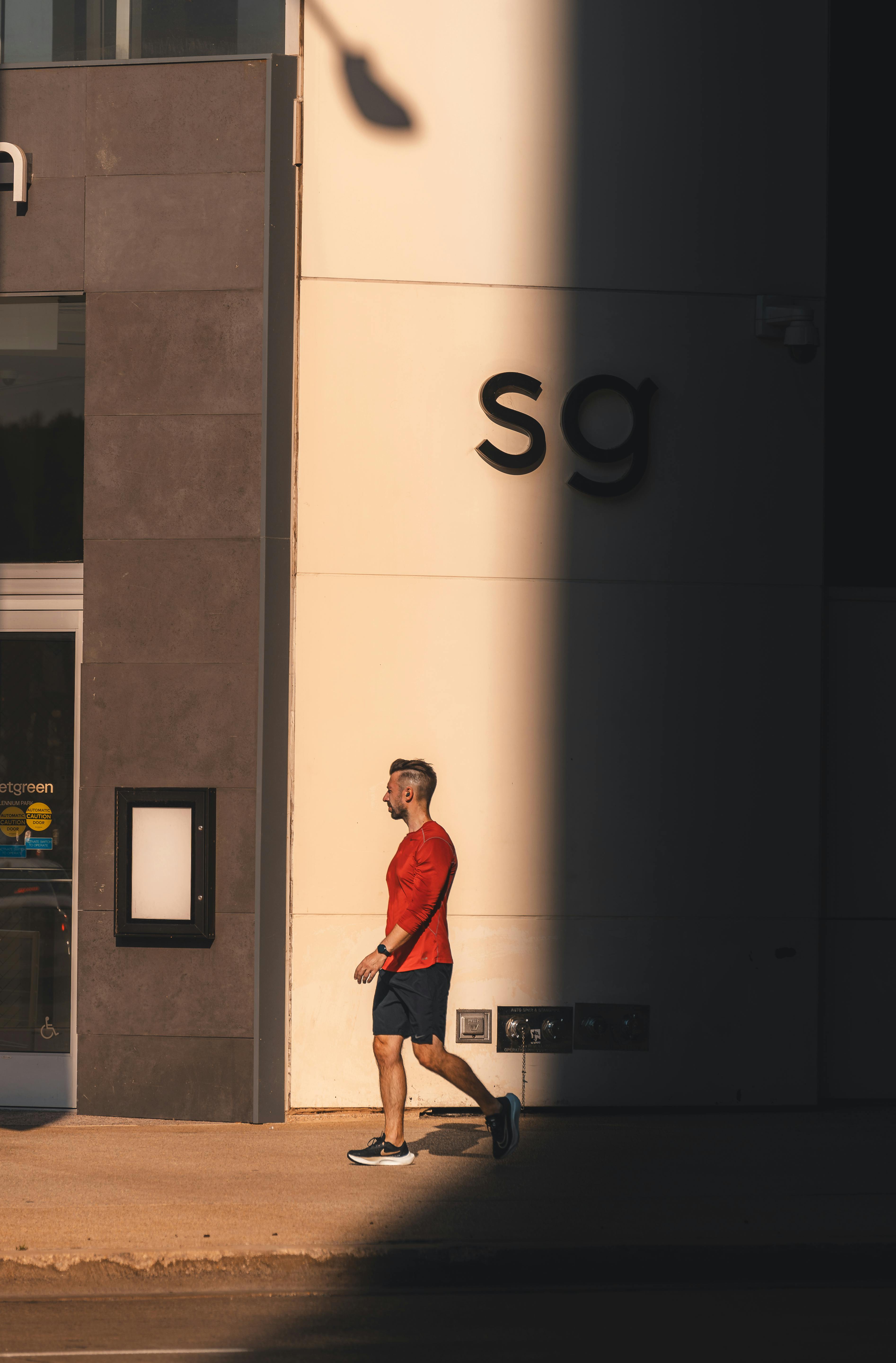 bezplatná Muž Běhání Vedle Budovy Při Západu Slunce Základová fotografie