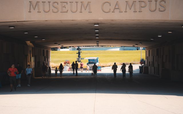 Photo: Willian Justen de Vasconcellos on Pexels Silhouette of visitors walking through a tunnel at Museum Campus, leading outdoors.