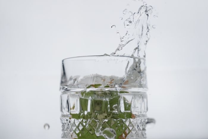 A refreshing water splash in a crystal glass with fresh mint leaves