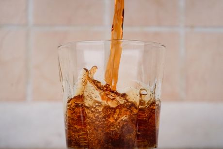 Cola being poured into a glass with a splash effect — photo by Beyzanur K. on Pexels