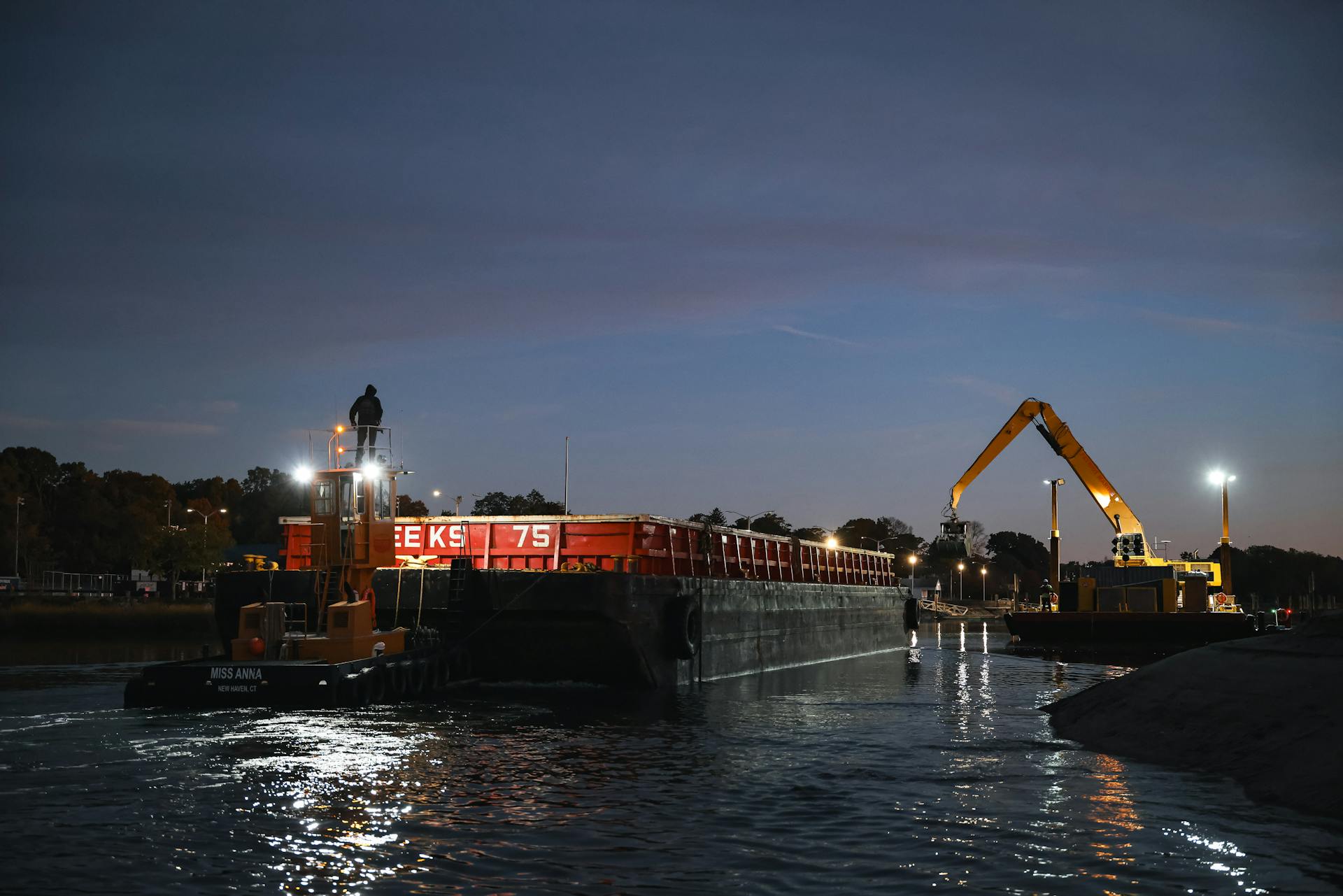 Twilight scene of a barge and dredging equipment at a marina in Stamford, Connecticut.