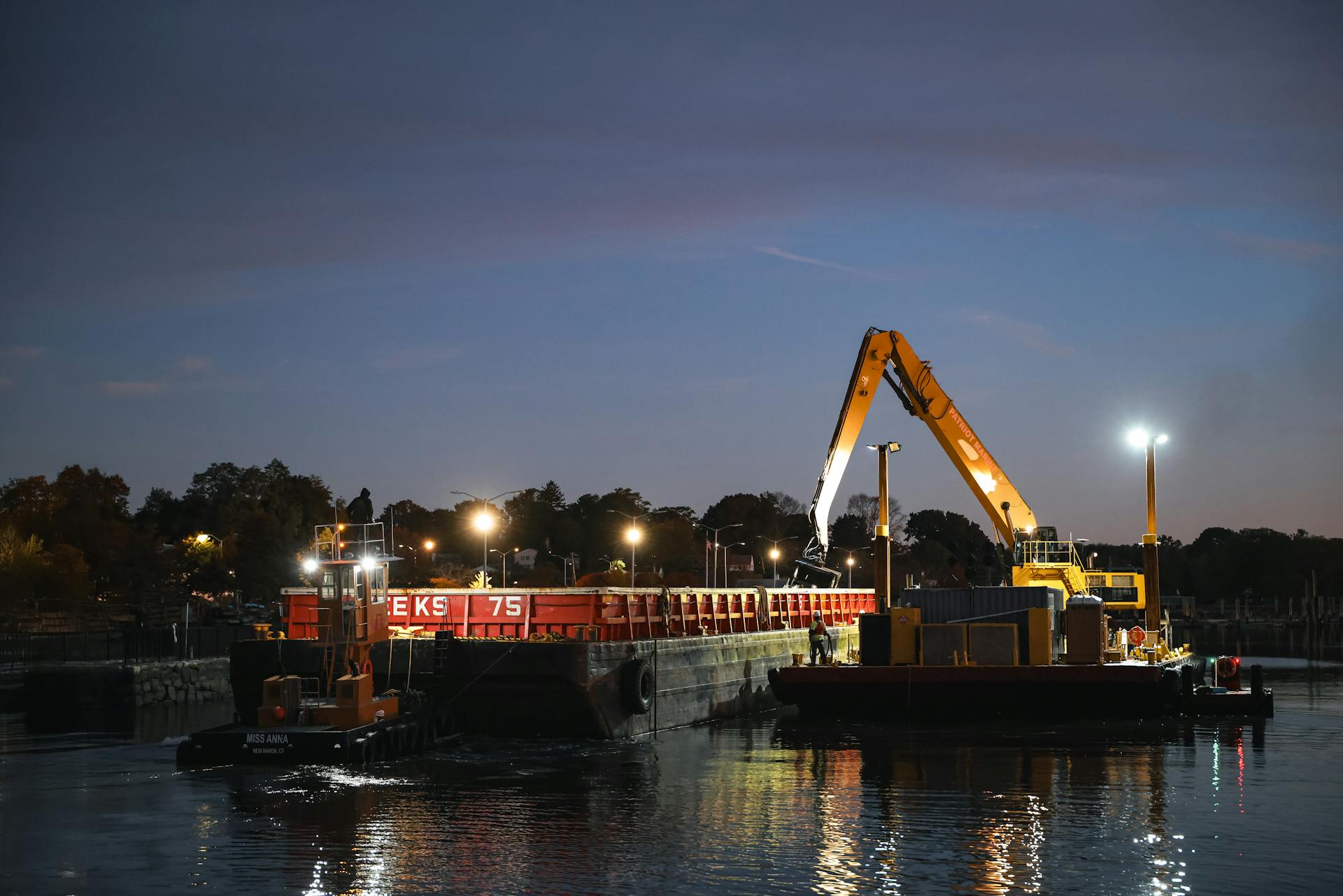 Heavy equipment dredging at dusk in Stamford Marina, Connecticut, creating a striking industrial scene.