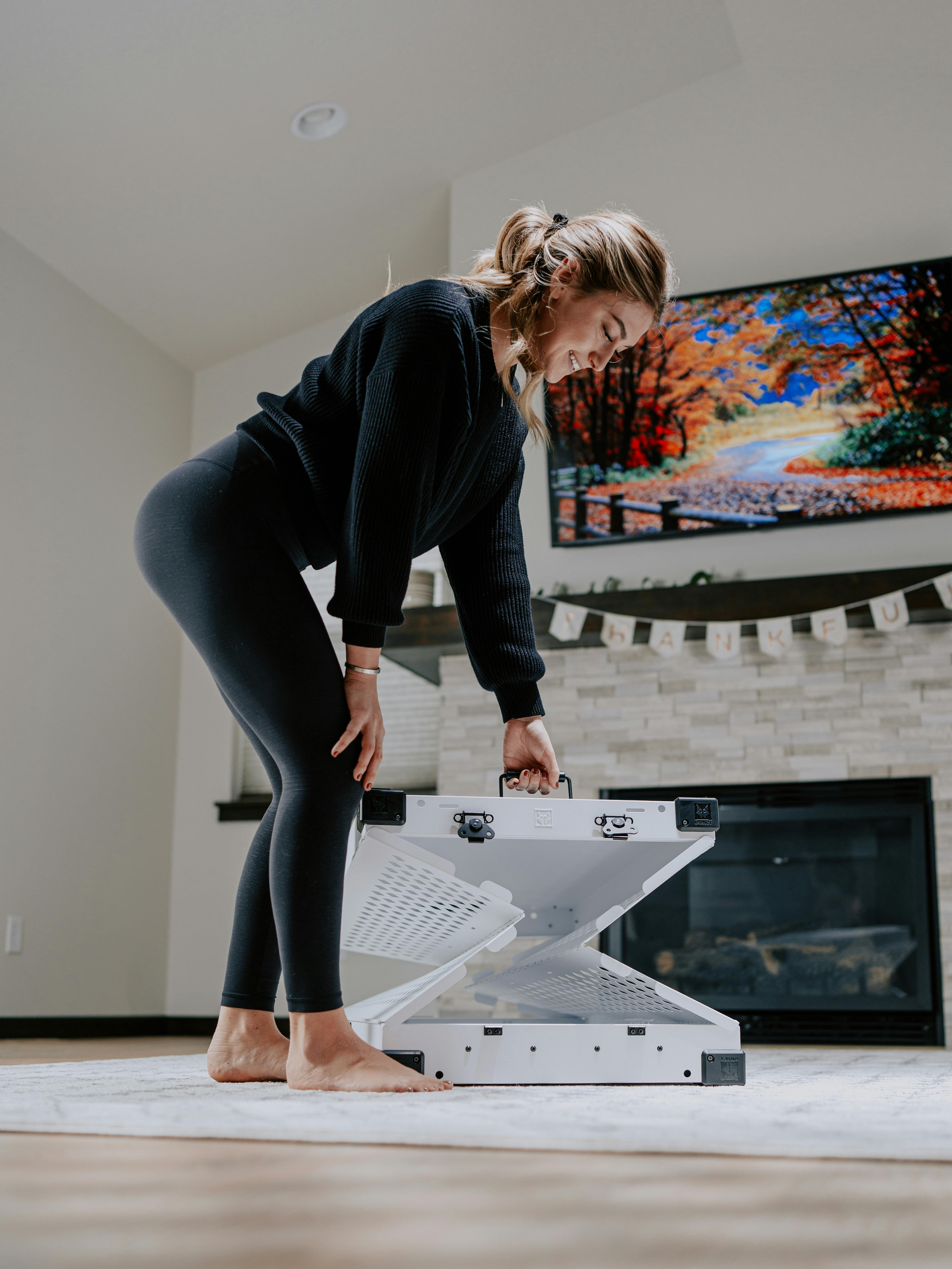 Une Femme Installe Une Cage Pliable Pour Chien à La Maison · Photo gratuite