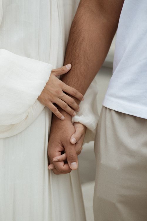 Free A close-up image depicting the hands of a couple holding each other in a gentle embrace. Stock Photo