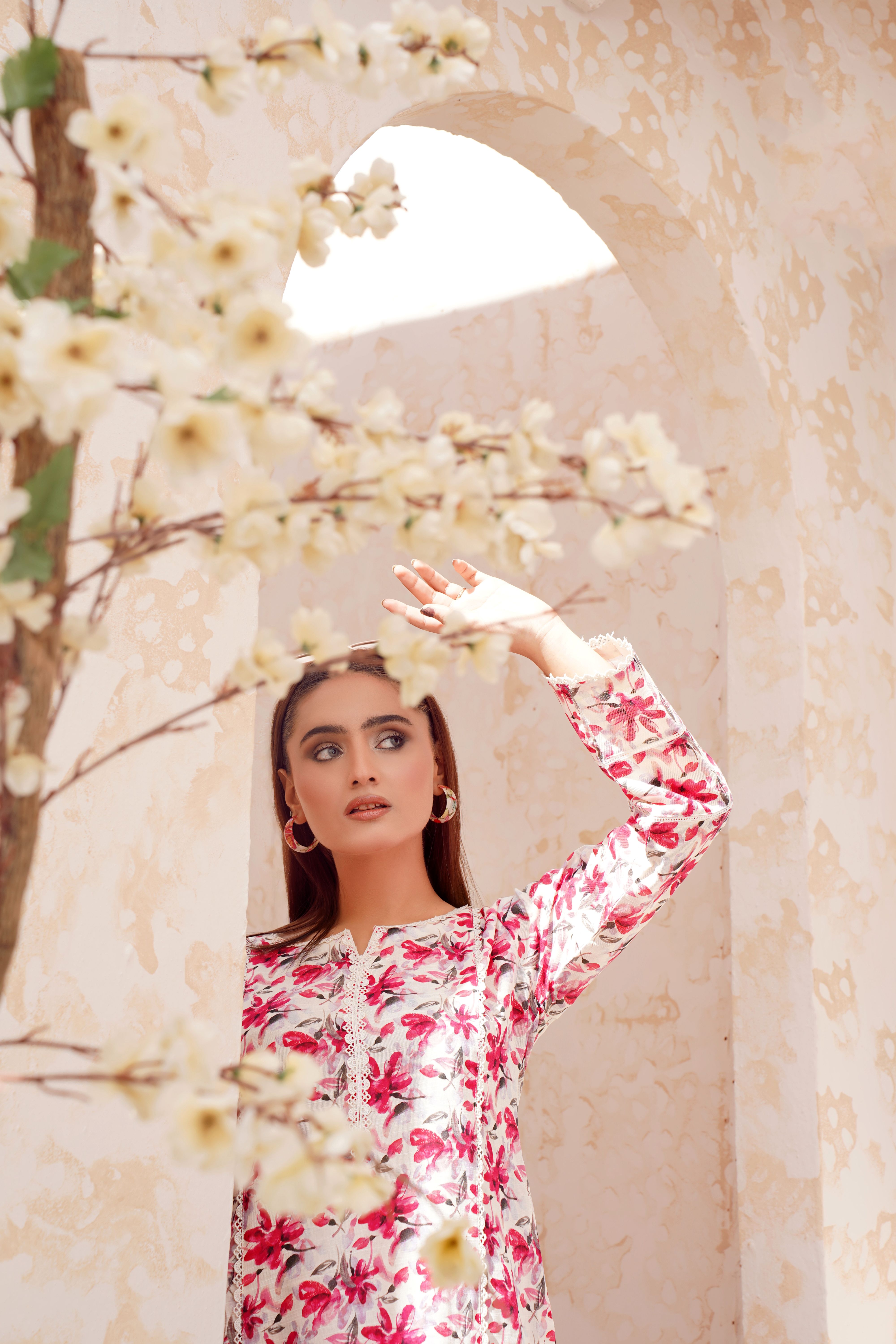 Fashionable South Asian woman in floral dress posing gracefully in Lahore, Pakistan.