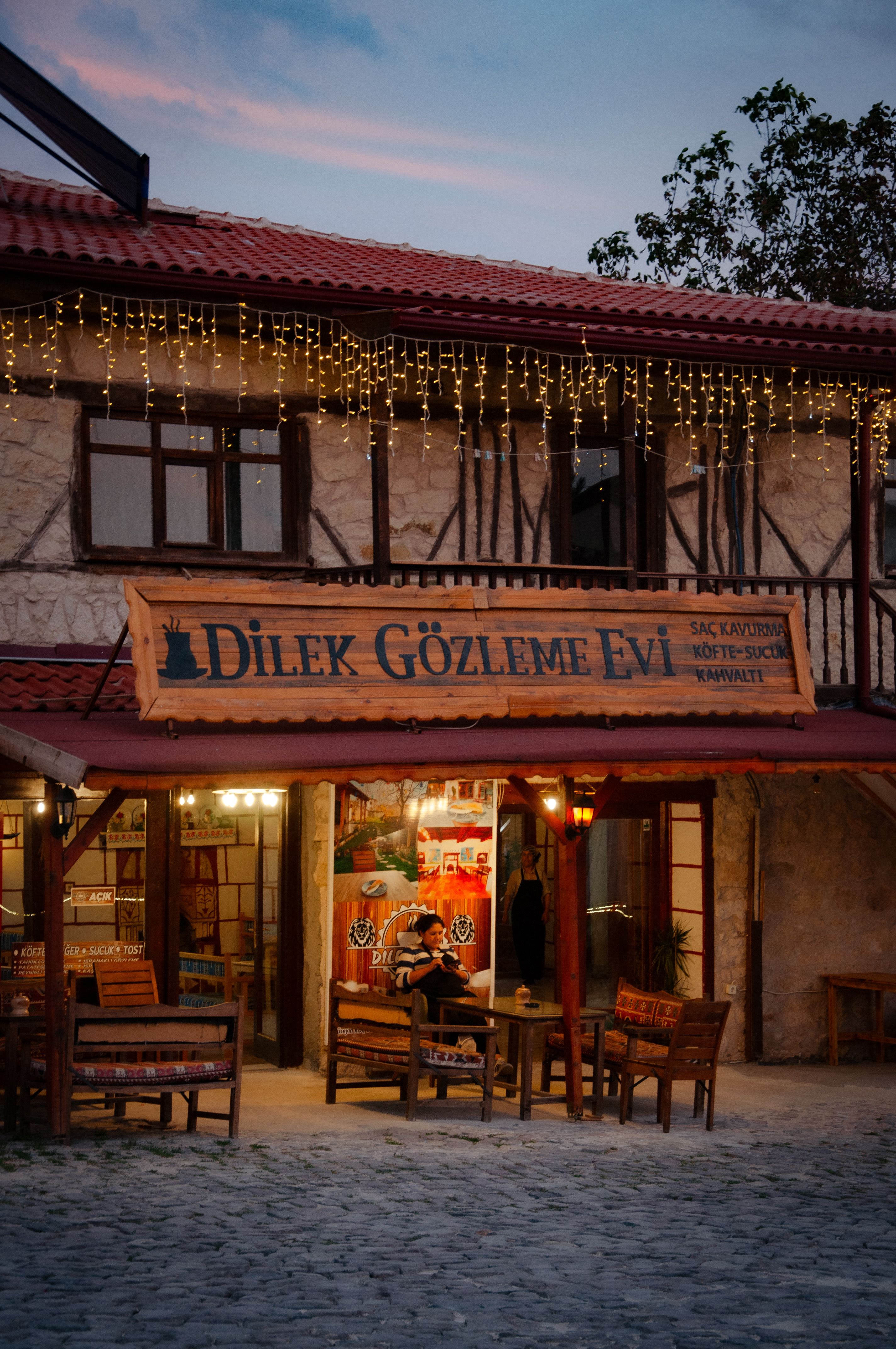 Warm, inviting atmosphere at Dilek Gözleme Evi with evening lights and charming decor.