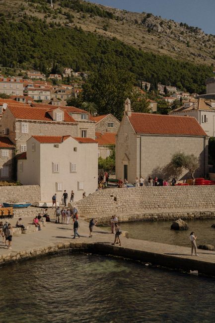 Tourists explore the historic architecture and scenic beauty of Dubrovnik's old harbor in Croatia.