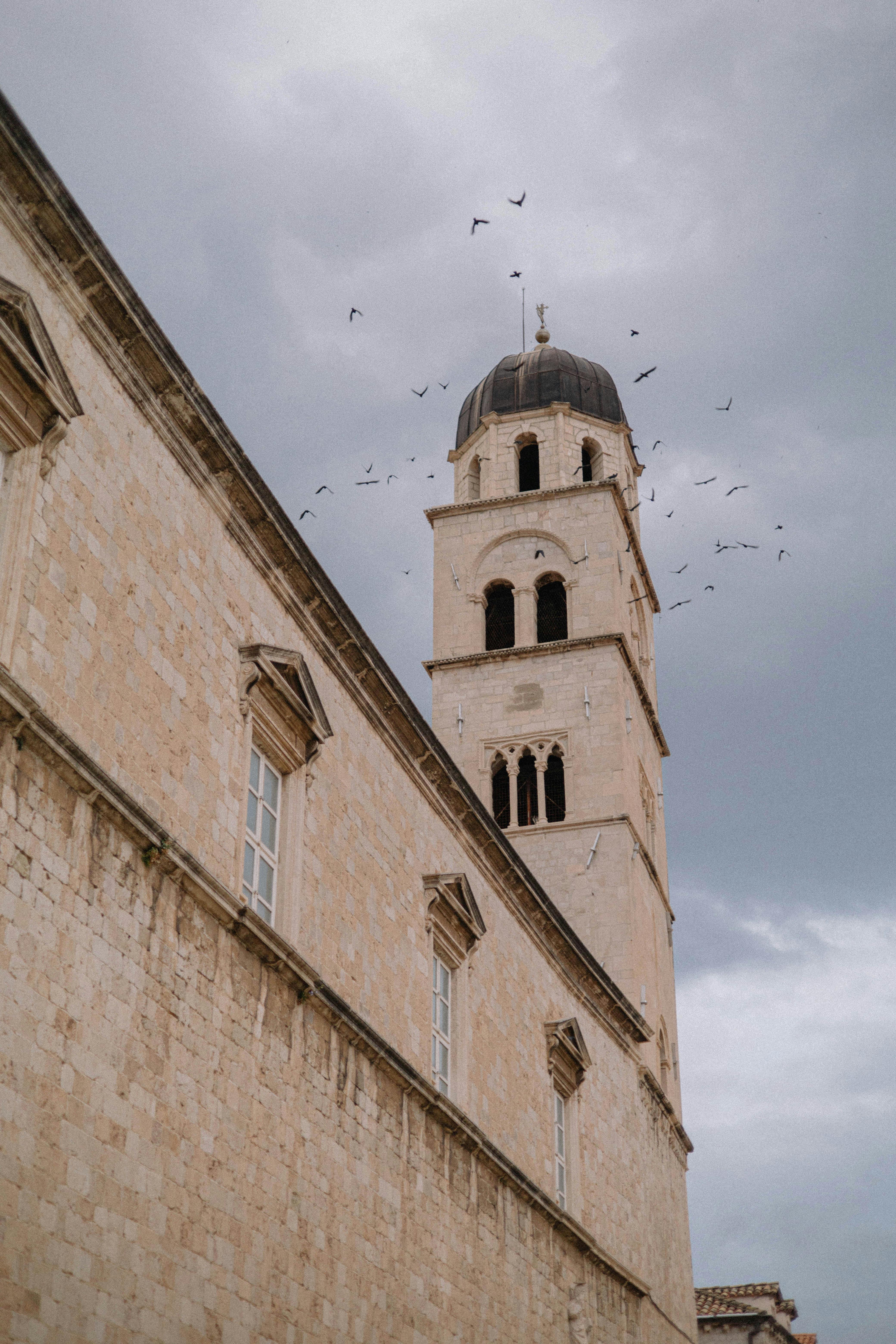A stunning view of the historic bell tower against a cloudy sky in Dubrovnik, Croatia.