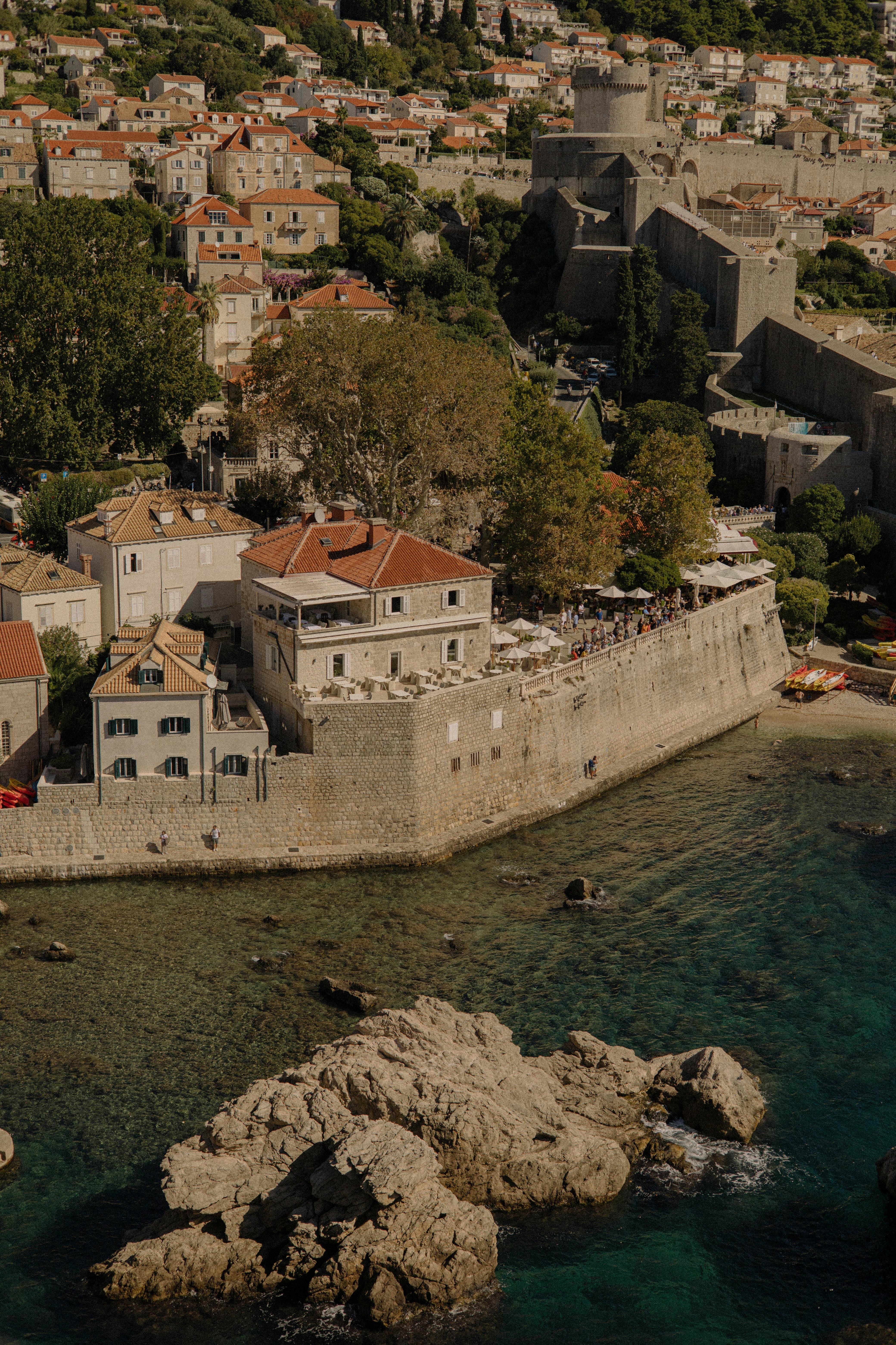 Scenic aerial view of Dubrovnik's historic coastline with ancient walls and clear waters.
