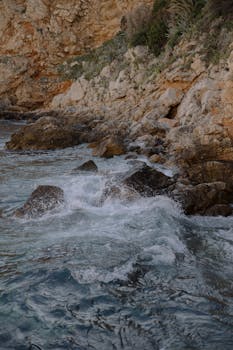 Waves crash against the rocky coastline in Dubrovnik, offering a serene natural scene.