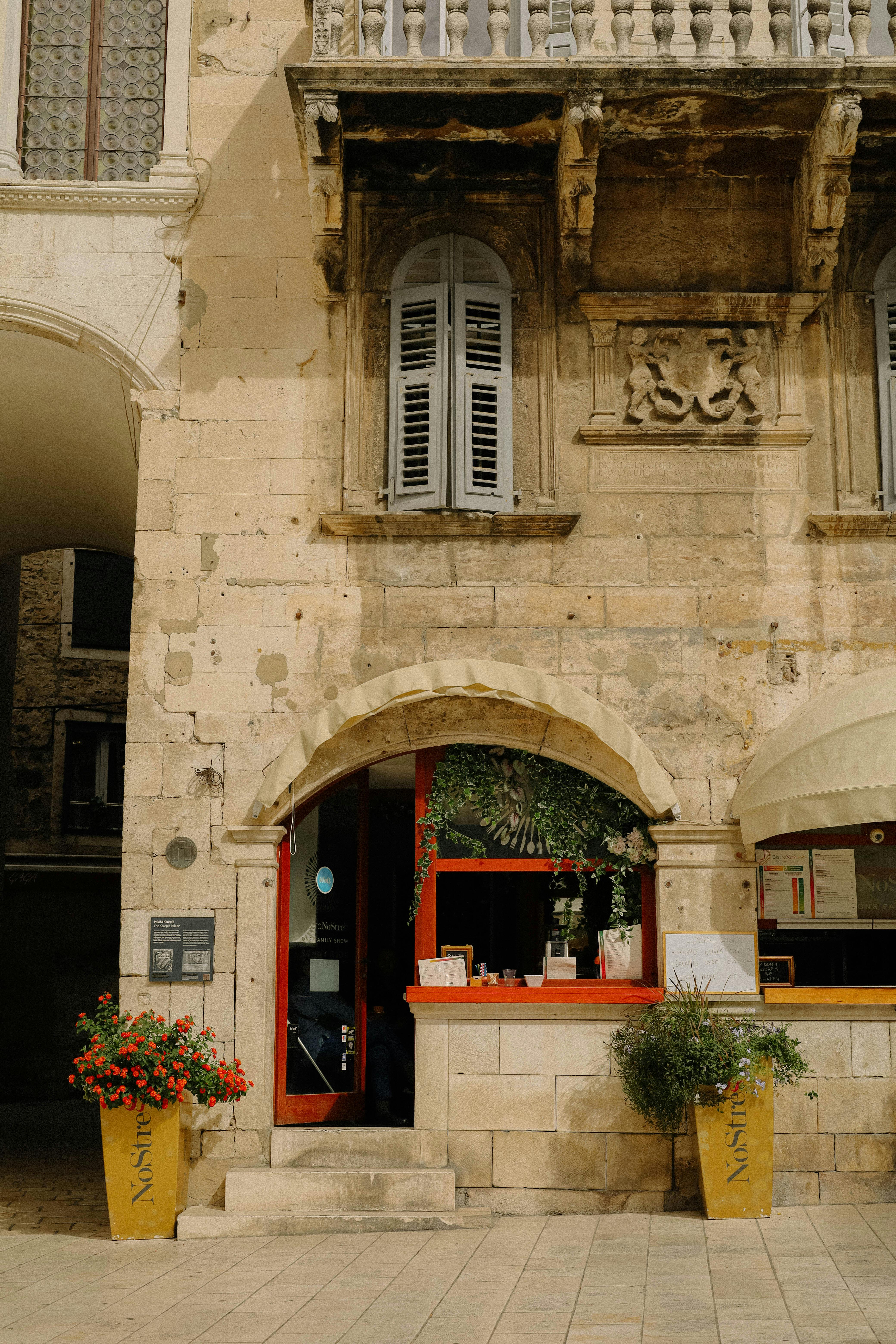 A quaint stone building with vibrant flowers in historic Dubrovnik, Croatia.
