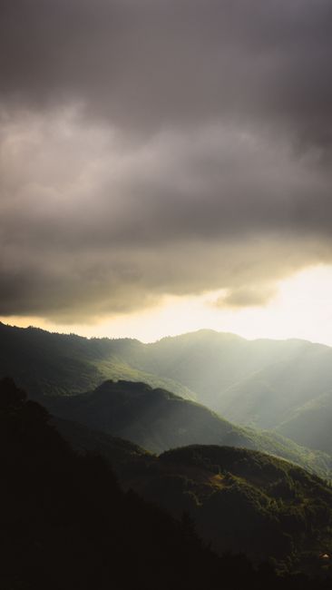 Sunlight breaking through clouds over Erbaa's mountains, creating a dramatic scene.