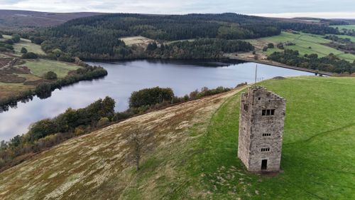 Free Scenic aerial view of Derwent Reservoir with a historic tower in Peak District, UK. Stock Photo