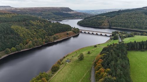 Free Aerial view of Ladybower Reservoir surrounded by lush greenery and hills in Derbyshire, England. Stock Photo