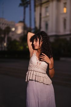 A young woman poses gracefully outdoors, highlighting evening elegance.