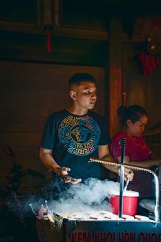 Vibrant night market scene with a vendor selling ice cream using dry ice for a smoky effect.