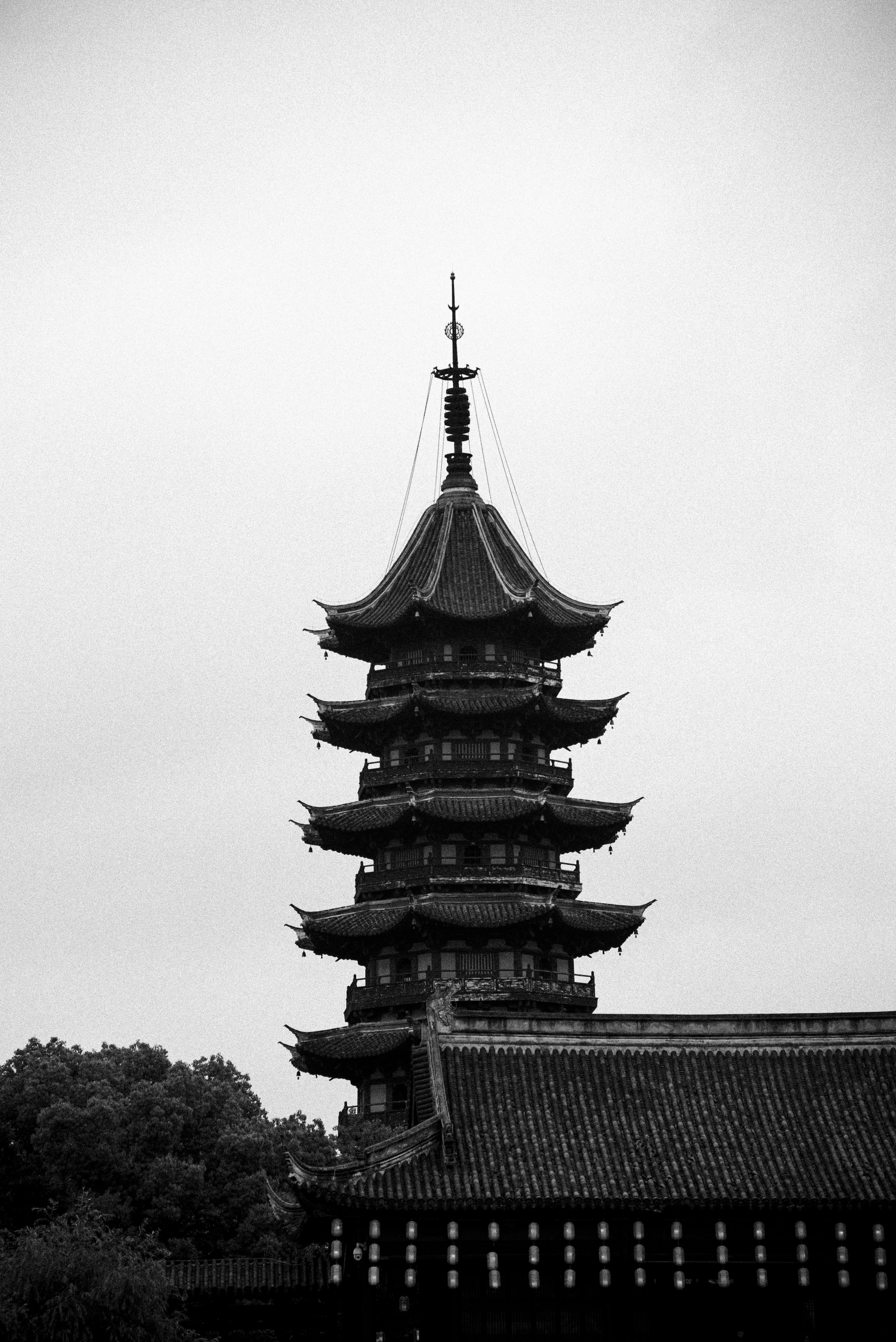 A stunning black and white photo of a traditional Asian pagoda, captured in silhouette against the sky.