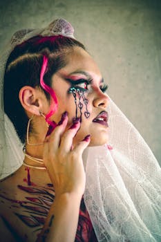 Stunning portrait of a woman in artistic bridal makeup and veil, highlighting tattoos in Ciudad de México.