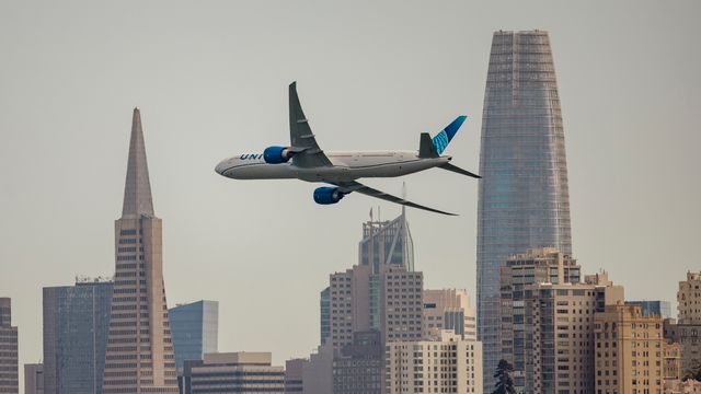 A United Airlines jet soaring over the iconic San Francisco skyline. — lounges at San Francisco Airport