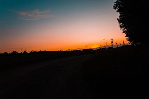Free Serene sunset sky over a tranquil Lithuanian countryside landscape, showcasing the beauty of nature. Stock Photo