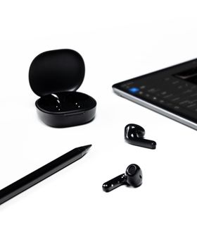 Sleek black wireless earbuds with tablet and stylus on a clean white surface.