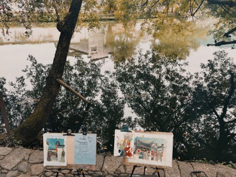 Artistic scene featuring river reflections and paintings by the riverside in Huangshan, China.