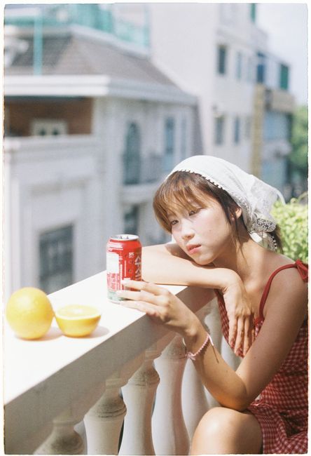 Casual summer scene with a young woman and a soda can, enjoying the sun.