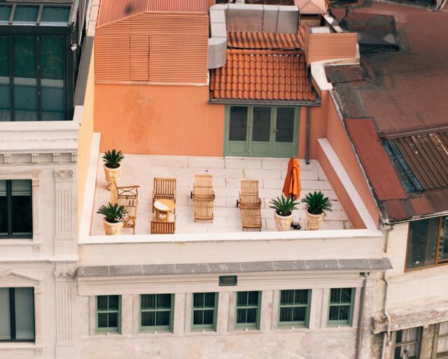 Rooftop deck with seating Urban rooftop deck with outdoor chairs and green plants