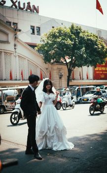 Bride and groom in a busy Hanoi street, capturing the essence of urban romance.