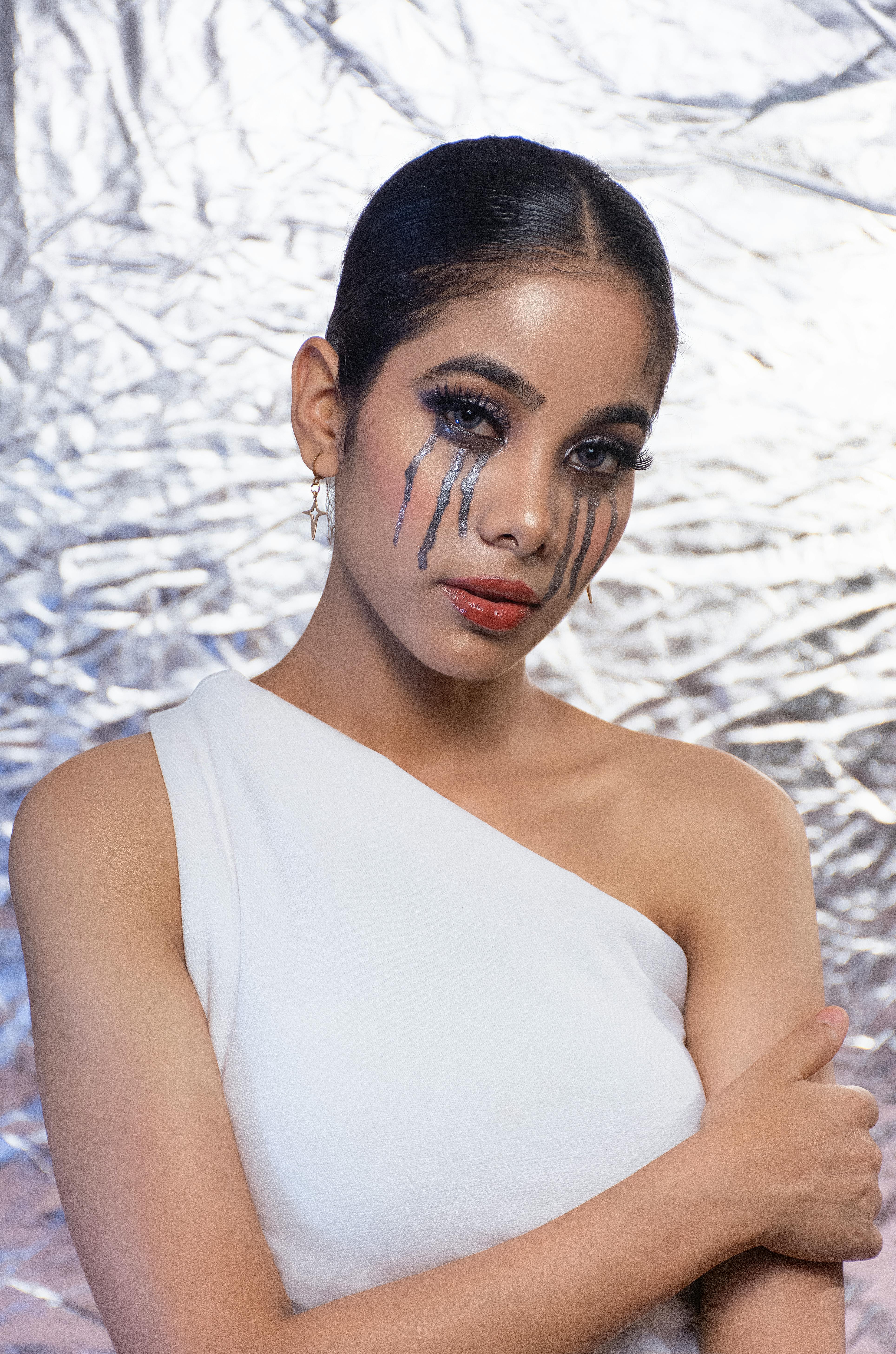 Striking portrait featuring artistic makeup with bold tear-like designs.