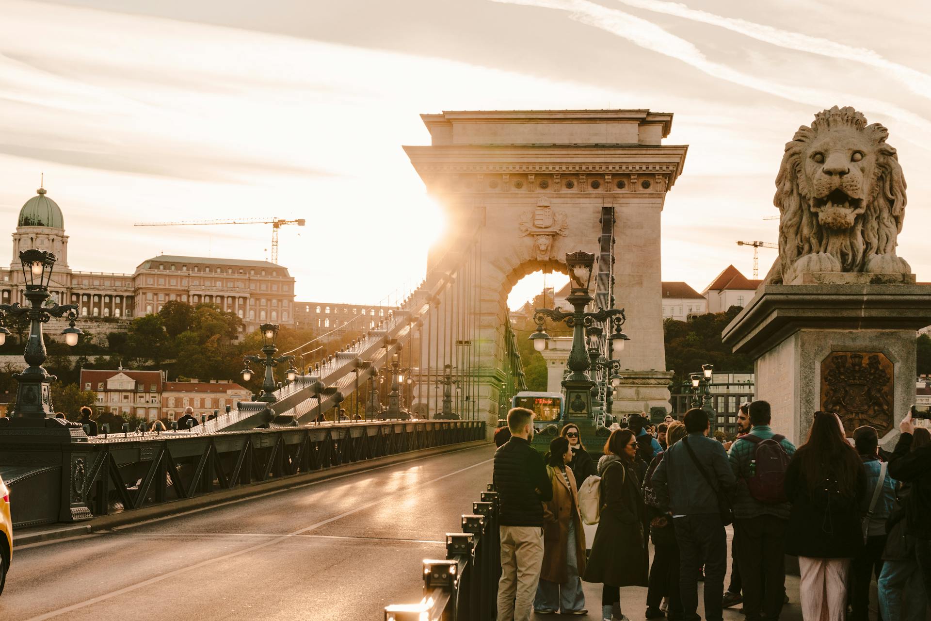 View of Széchenyi Chain Bridge with tourists and sunset in Budapest, Hungary.